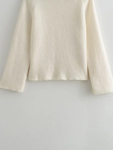 Détail de la texture en maille côtelée blanc cassé et du tissu de ce pull à manches longues
