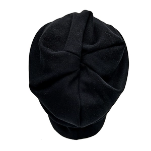 Top view of a black knitted beanie featuring a unique radial twisted knot design