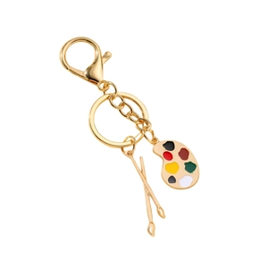 Artistic gold palette keychain with colorful enamel paint and crossed paintbrushes charms