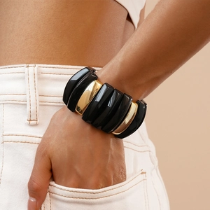 Detail of wide stretch bracelet featuring alternating black resin and gold metal segments