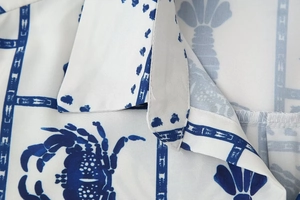 Detailed close-up of V-neck shirt collar with blue crab and abstract print pattern