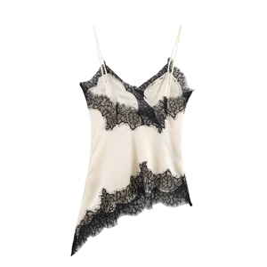 Detail shot of ivory satin camisole featuring black lace trim and asymmetrical hem design