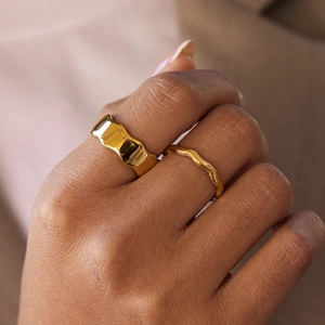 Close-up of dual 18k gold plated stainless steel wavy rings on model finger
