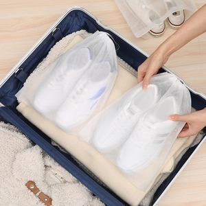 Breathable non-woven shoe storage bags for travel packing shown in a suitcase