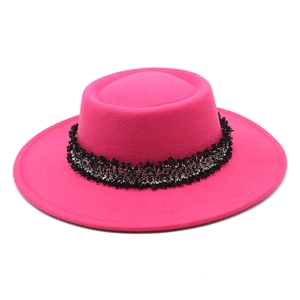 Detalle de sombrero de lana fucsia con cinta de flecos de tweed en blanco y negro