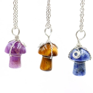 Vue macro de pendentifs champignons faits main en améthyste, oeil de tigre et sodalite