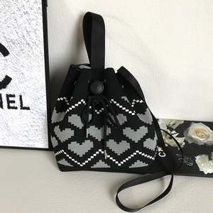 Detailed close-up of heart pattern jacquard knit texture on drawstring bucket bag