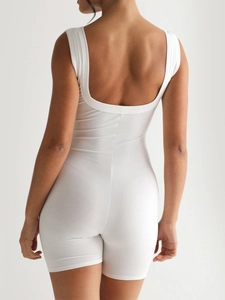 Detail of white ribbed yoga jumpsuit featuring a U-shaped open back on a model