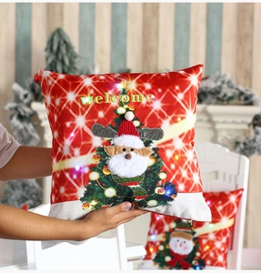 Détail d'une housse de coussin de Noël à LED rouge avec broderie et texte de bienvenue