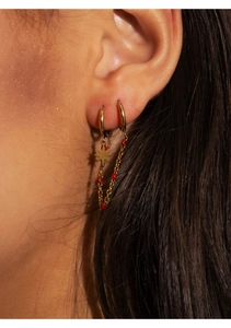 Detail of bohemian gold double hoop earring with red beads and star charm on model