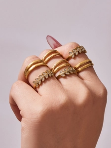 Detail of stacked 18k gold plated leaf and zircon rings on a model's hand