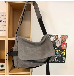 Gray vintage canvas messenger bag detail with adjustable strap in a lifestyle setting
