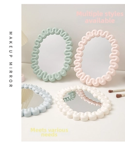 Detailed close-up of oval wavy makeup mirrors in pastel mint, pink, blue and cream white