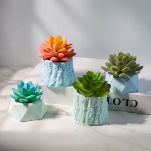 Set van vier kunstmatige vetplanten in decoratieve geometrische en schorsachtige potten