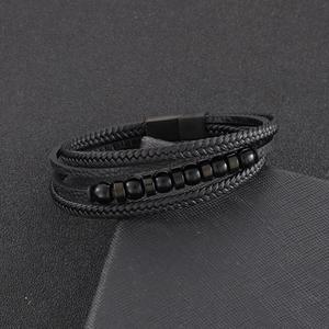 Close-up of men's multilayer braided leather bracelet with black beads and magnetic clasp