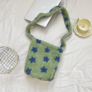 Detailed top view of a green faux fur tote bag with blue flower patterns on white fabric