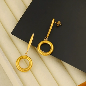 Close-up of 18K gold plated hoop earrings with intricate floral textured pendant