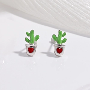 Macro shot of silver cactus stud earrings with green enamel and a red heart detail