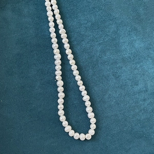 Macro shot of natural baroque pearls on dark velvet fabric highlighting texture and iridescence