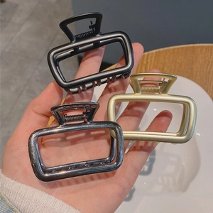 Three-piece metal hair claw set in matte black, gold and silver finishes with hollow design