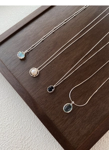 Detailed close-up of S925 sterling silver necklaces with opal, pearl and gemstone pendants