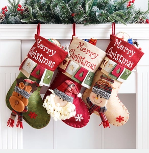 Three large Christmas stockings with reindeer and Santa icons hanging on a white fireplace