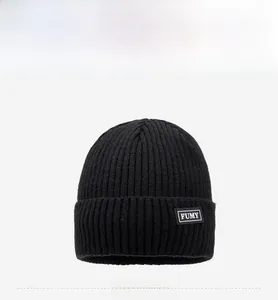 Detail view of the black ribbed knit beanie featuring the FUMY woven label on the front