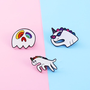 Whimsical white unicorn and rainbow ghost enamel pins set on a pastel background
