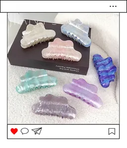 Flat lay of seven colorful cloud-shaped acrylic hair claws with marble texture