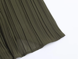 Detailed macro view of the olive green pleated fabric texture and hem stitching of the midi dress