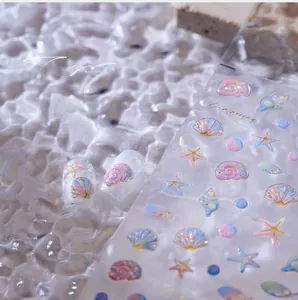 Detailansicht der 3D-Nagelaufkleber mit Muschel- und Seesternmotiven und Goldfolie