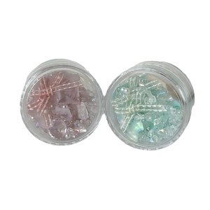 Sparkling crystal nail art rhinestones and pearls in pink and green jars for manicures