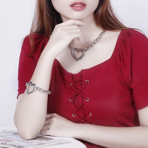 Close-up of chunky silver chain necklace and bracelet set with large heart pendant