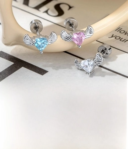 Detail of heart zircon wing cartilage studs in blue, pink, and clear polished finishes