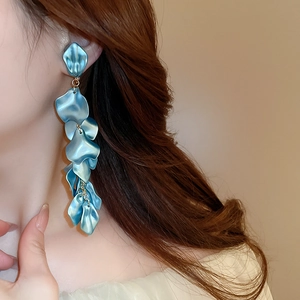Close-up of elegant blue petal tassel earrings on model showing pearlized texture and long design