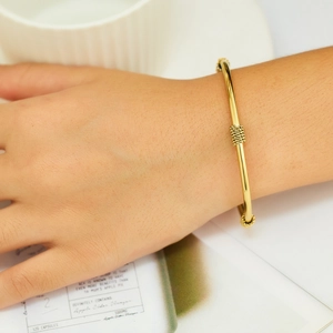 Retro C-shaped 18k gold plated stainless steel knot bangle for women shown on wrist