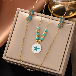 Close-up of gold chain necklace with blue infinity symbols and star pendant