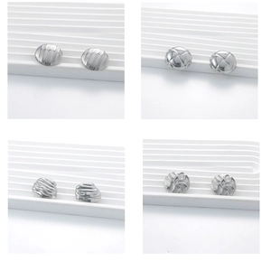Macro shot of four pairs of silver stainless steel round earrings with textured patterns