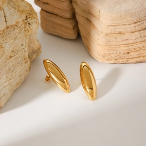 Minimalist golden oval stud earrings in polished stainless steel on a natural stone base