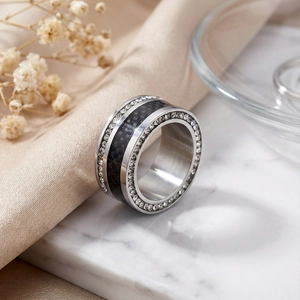 Close-up of wide titanium steel ring with black carbon fiber inlay and double row zircons
