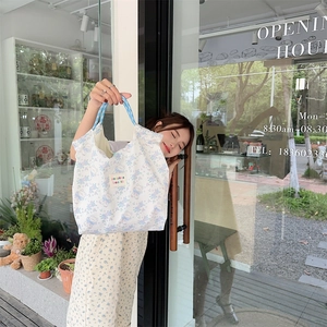 Detail of canvas tote bag with teddy bear pattern and blue polka dot straps