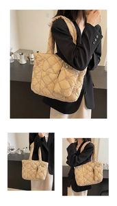Detail of beige quilted tote bag featuring floral embroidery and matching small pouch