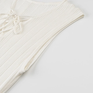 Detail of white knit dress neckline with elegant lace-up tie and ribbed texture