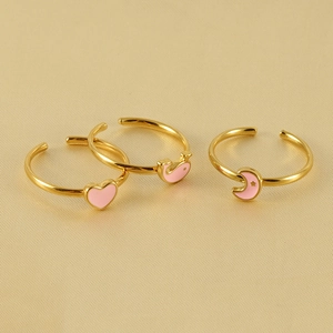 Three gold-plated adjustable rings with pink enamel heart, whale, and moon pendants