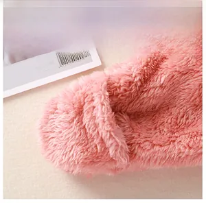 Detail eines rosa Plüsch-Baby-Einteilers mit schützendem Kratzschutz-Handschuh