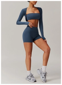 Detailed close-up of blue three-piece yoga set with crop top and high waist shorts