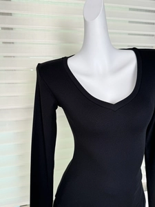 Détail d'un haut noir à manches longues et col en V en maille côtelée douce sur mannequin