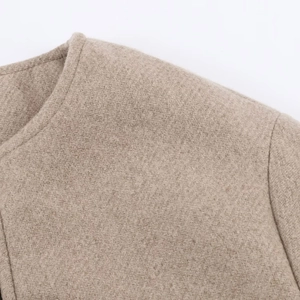 Détail de l'encolure ronde et du tissu en mélange de laine d'une veste beige clair