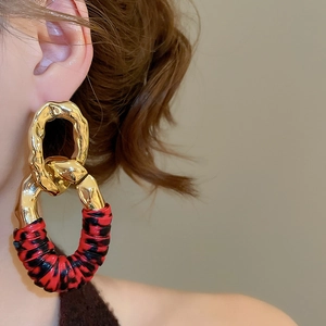 Macro shot of gold hammered metal hoops with red and black leopard print textile wrap