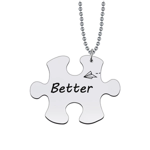 Detailed close-up of a silver puzzle necklace with Better engraving and plane icon